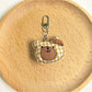 Close-up of the bear charm keychain’s embroidered eyes and nose