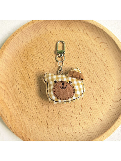 Close-up of the bear charm keychain’s embroidered eyes and nose
