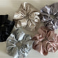 Gifty satin scrunchie wrapped around a ponytail on a model with dark hair