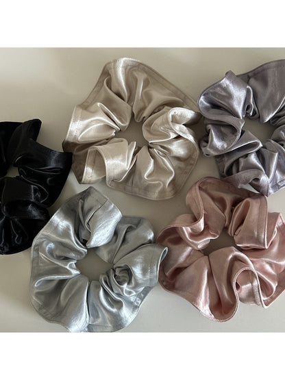 Gifty satin scrunchie wrapped around a ponytail on a model with dark hair