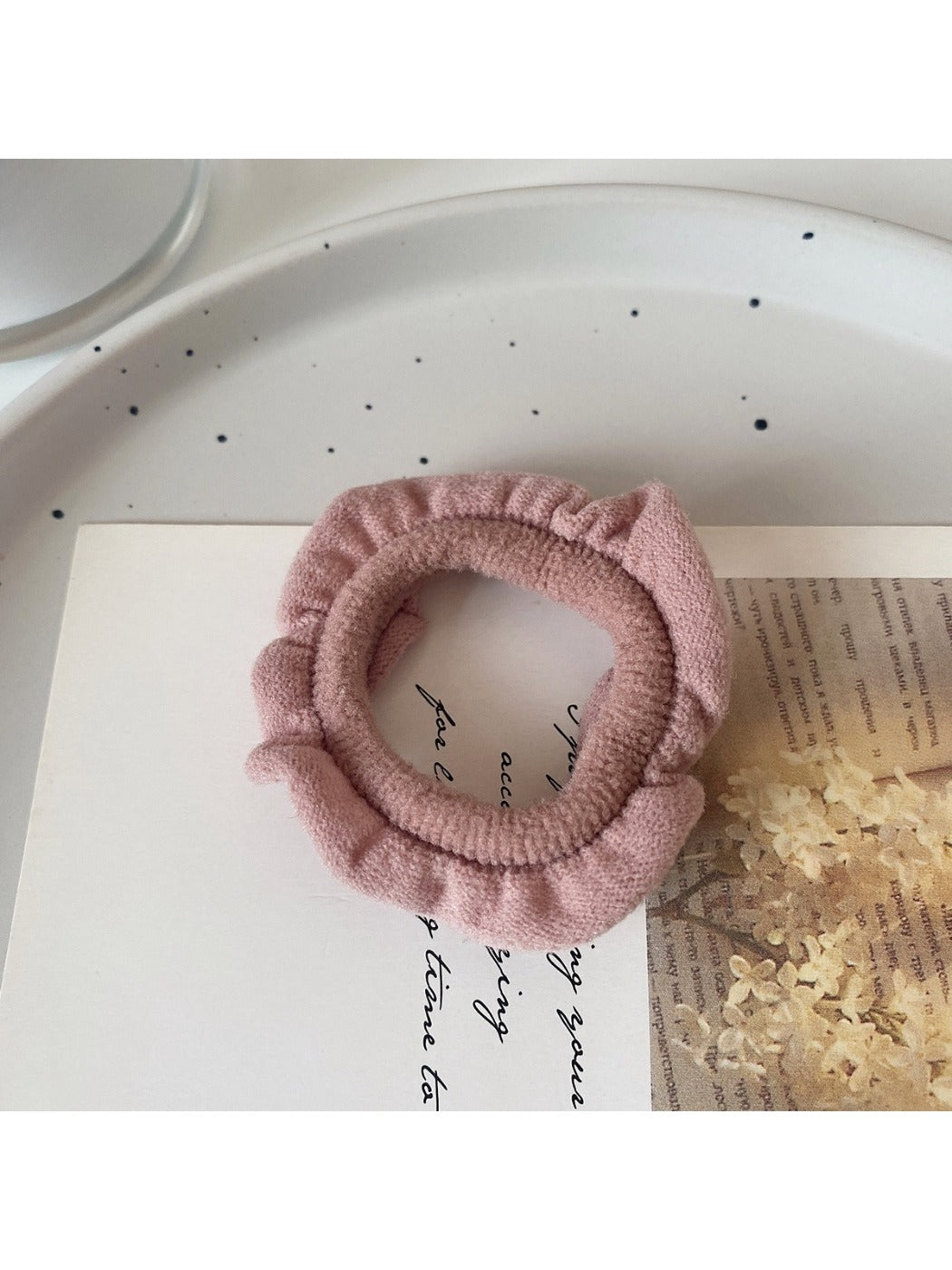 Ruffled hair ties in multiple colors arranged in a fan shape on a white surface