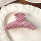 Top view of Beau pink plaid crescent shaped claw clip showing curved design