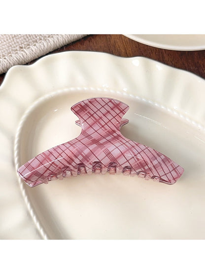 Top view of Beau pink plaid crescent shaped claw clip showing curved design