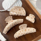 Close-up of Beau chic brown butterfly print claw clip on white background