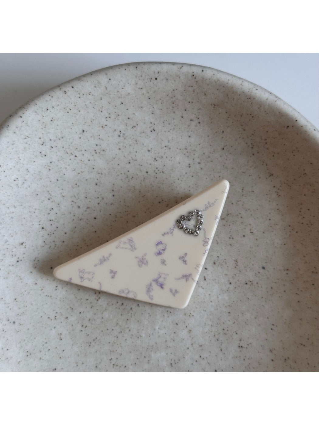 Beau triangle star hair clip clipped onto dark hair highlighting contrast and style