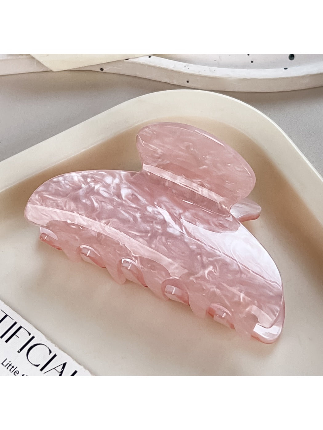 Beau macaron colored claw clip displayed on a wooden surface