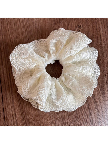 Gifty lace scrunchie wrapped around a ponytail on a model outdoors
