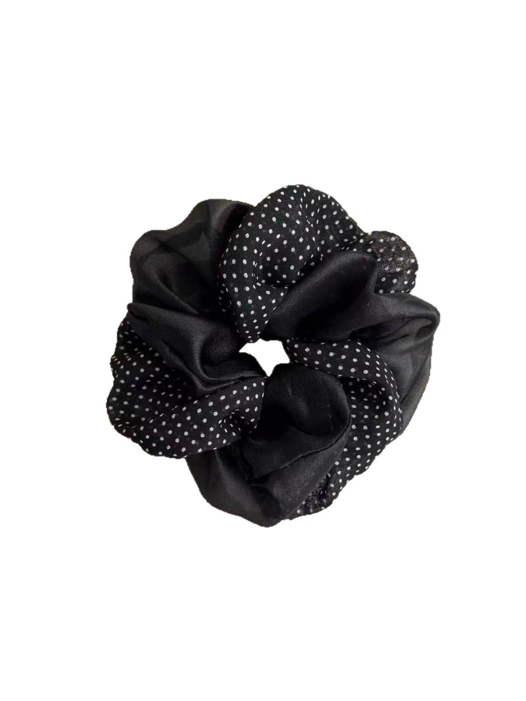 Close-up of beige tulle scrunchie featuring white polka dots and gathered fabric texture