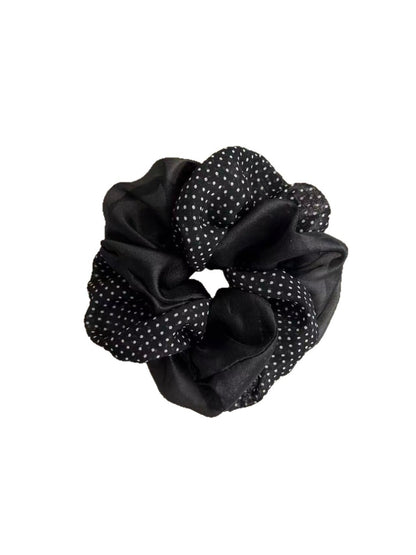 Close-up of beige tulle scrunchie featuring white polka dots and gathered fabric texture