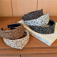 Side view of wide vintage print headband showing fabric texture and colors