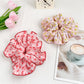 Polka dot scrunchie wrapped around a ponytail on a model with brown hair
