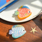 Side view of Beau tropical fish hair clip highlighting curved shape and clasp mechanism