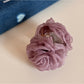 Beau rose hair clip placed on a wooden surface for display