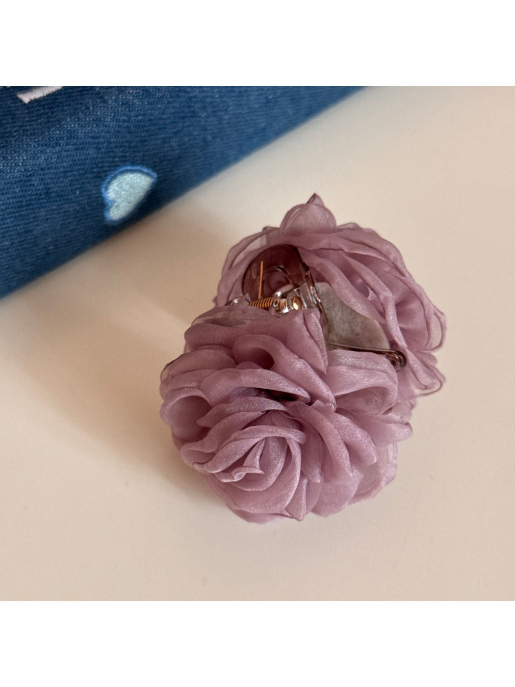Beau rose hair clip placed on a wooden surface for display