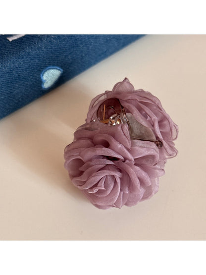 Beau rose hair clip placed on a wooden surface for display