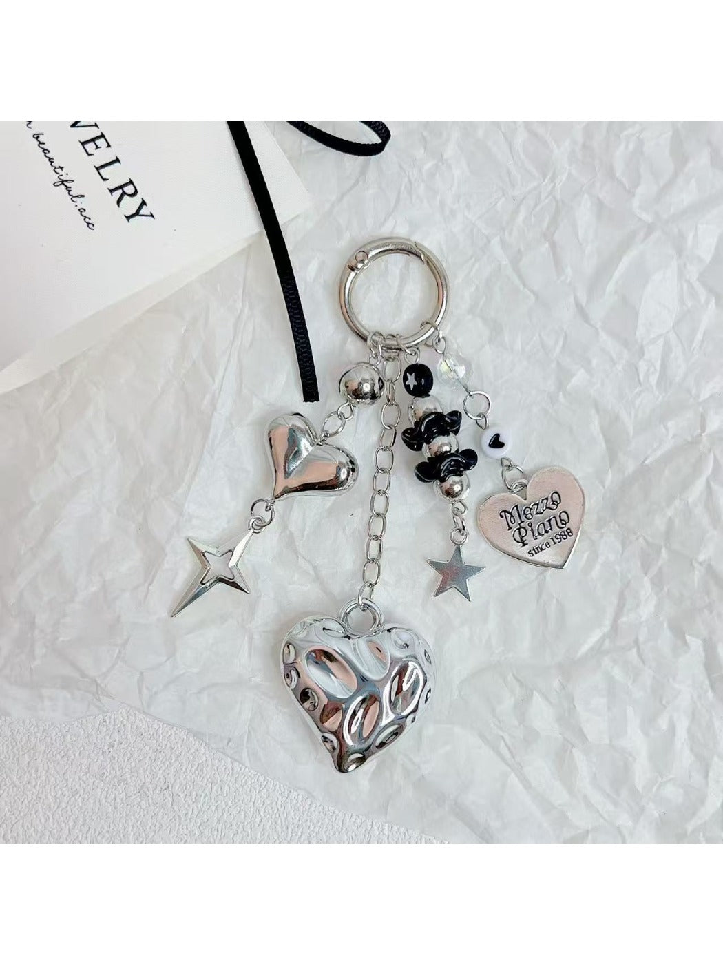 Silver minimalist heart keychain held in hand showing size and detail