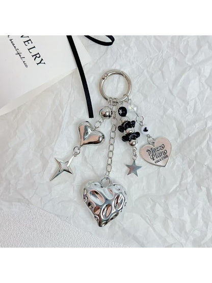 Silver minimalist heart keychain held in hand showing size and detail