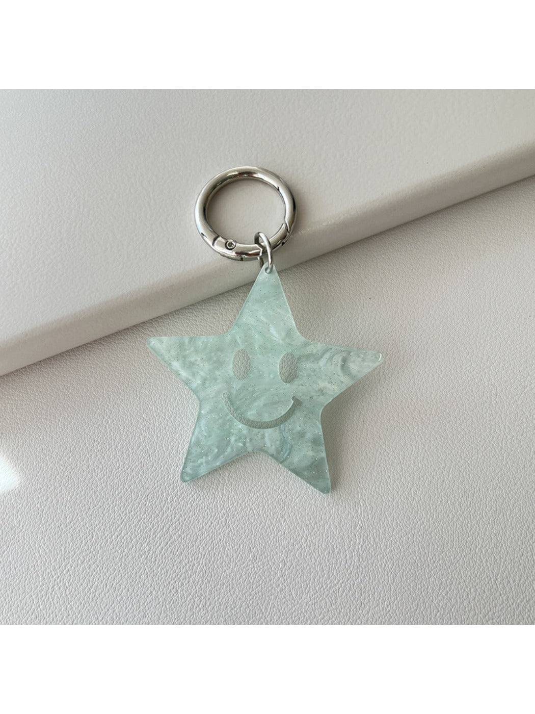 Silver star keychain attached to a set of house keys on a wooden table