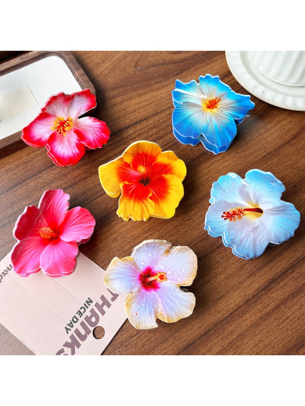 Beau lifelike hibiscus shaped claw clip in soft pink on white background