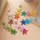 Close-up of Earedge cute star pendant earrings on white background