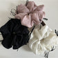 Side view of a pink tulle scrunchie with a large decorative ribbon bow