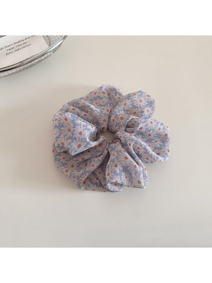 Model wearing Gifty daisy print scrunchie in hair with loose waves