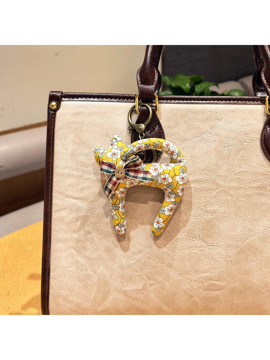 Keypus cartoon cat charm keychain hanging from a set of keys on a wooden surface