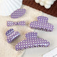 Purple plaid hair claw clip with curved teeth on white background