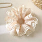 Close-up of Gifty Sweet Bow Print Ruffled Scrunchie with pink and white bow pattern