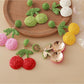 Pair of cherry shaped earrings made from natural raffia fibers