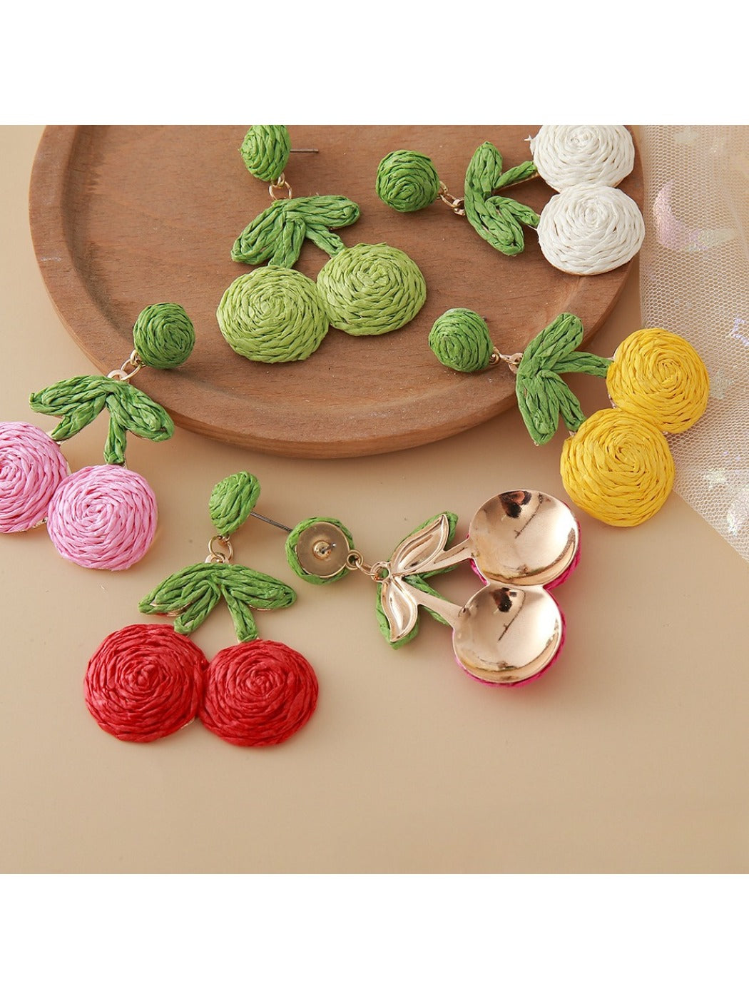 Pair of cherry shaped earrings made from natural raffia fibers
