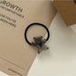Rose hair tie wrapped around a ponytail on dark brown hair
