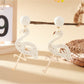 Flamingo pendant earrings worn on a model's ear with a blurred background