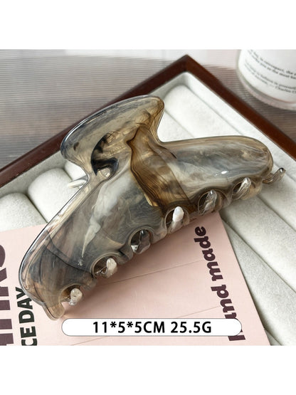 Beau plastic updo claw clip in beige displayed next to a matching hair accessory