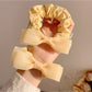 Close-up of Gifty sweet bow decorated hair tie in soft pink fabric