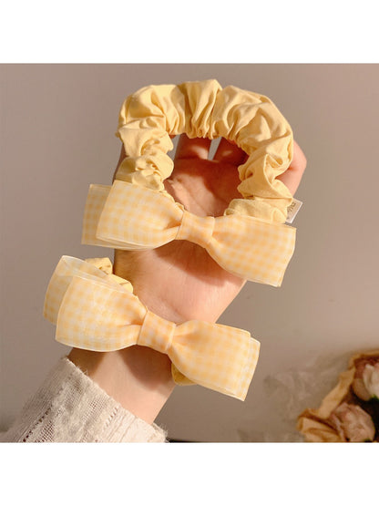 Close-up of Gifty sweet bow decorated hair tie in soft pink fabric
