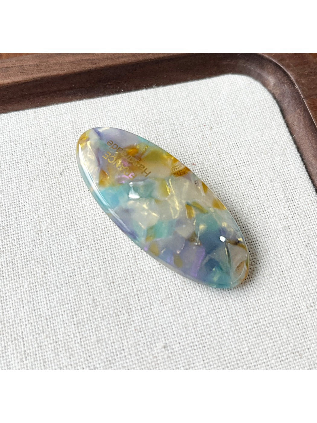 Beau Sweet Oval Acetate Hair Clip displayed on a wooden surface
