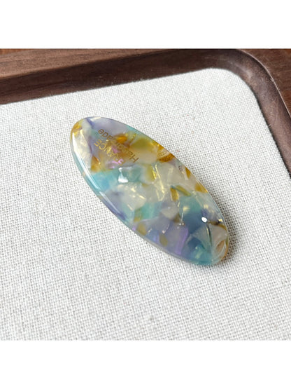 Beau Sweet Oval Acetate Hair Clip displayed on a wooden surface
