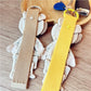 Fabric patchwork bear keychain attached to a metal keyring on a white background