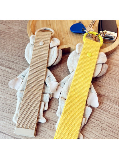 Fabric patchwork bear keychain attached to a metal keyring on a white background