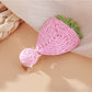 Beau raffia strawberry flower hair clip next to natural raffia strands
