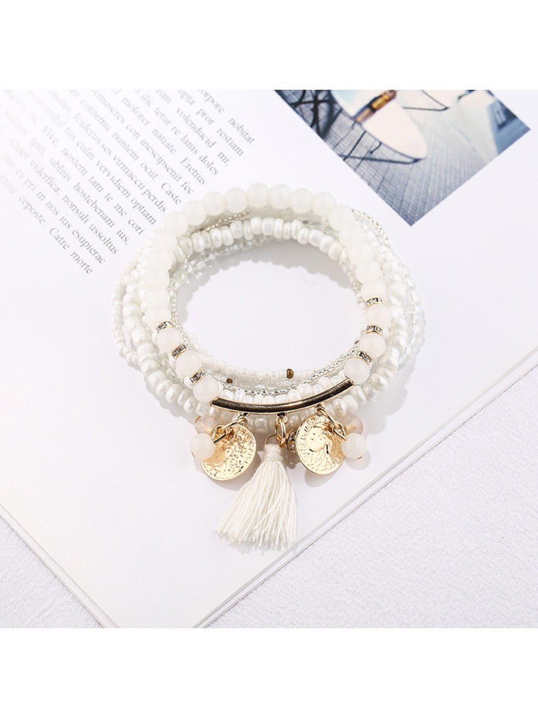 Lovra beaded bracelet wrapped around a wrist with metal tassel pendant