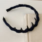 Side angle of pink corduroy headband showing fabric detail and elastic band