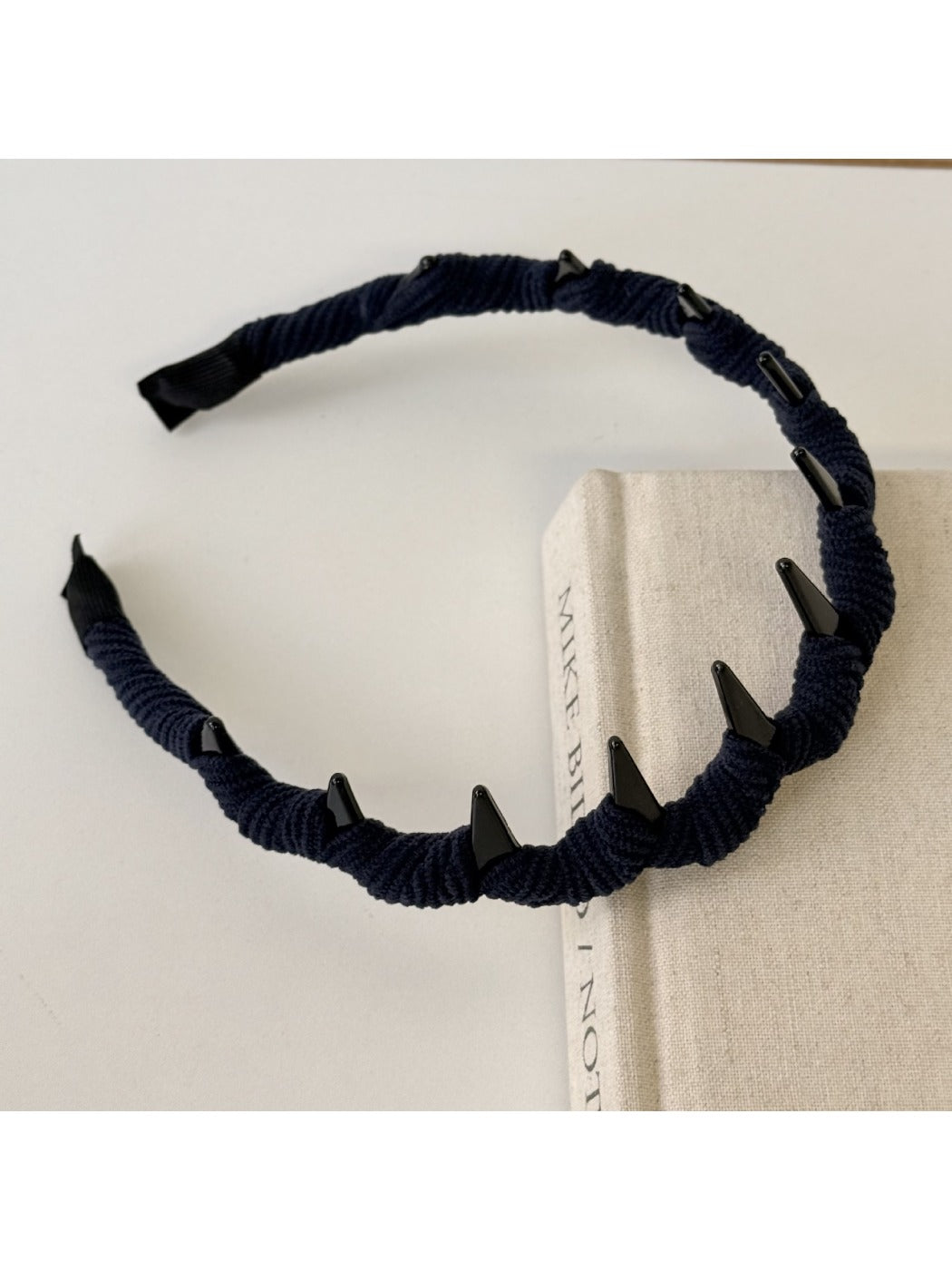 Side angle of pink corduroy headband showing fabric detail and elastic band