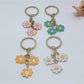 Sweet peach blossom shaped keychain with soft pink petals and gold keyring