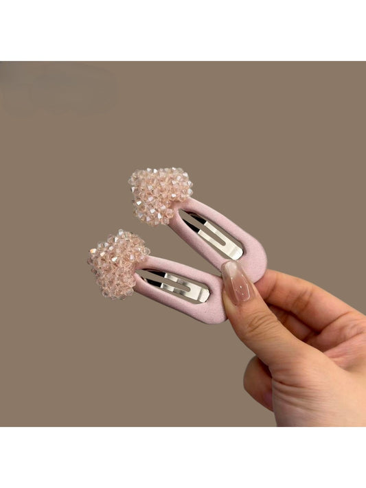 Close-up of a pink heart-shaped hair clip with a smooth finish