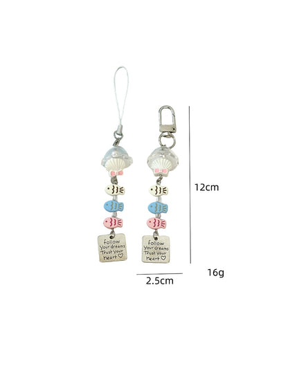 Side view of pastel yellow fish-shaped keychain highlighting its shape and finish