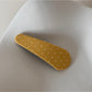 Beau polka dot hair clip on a wooden surface with soft lighting