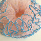 Four-layer ruffled scrunchie displayed flat showing its full circular shape