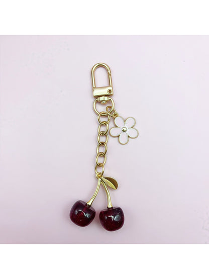 Cherry charm keychain displayed on a white background highlighting its glossy finish